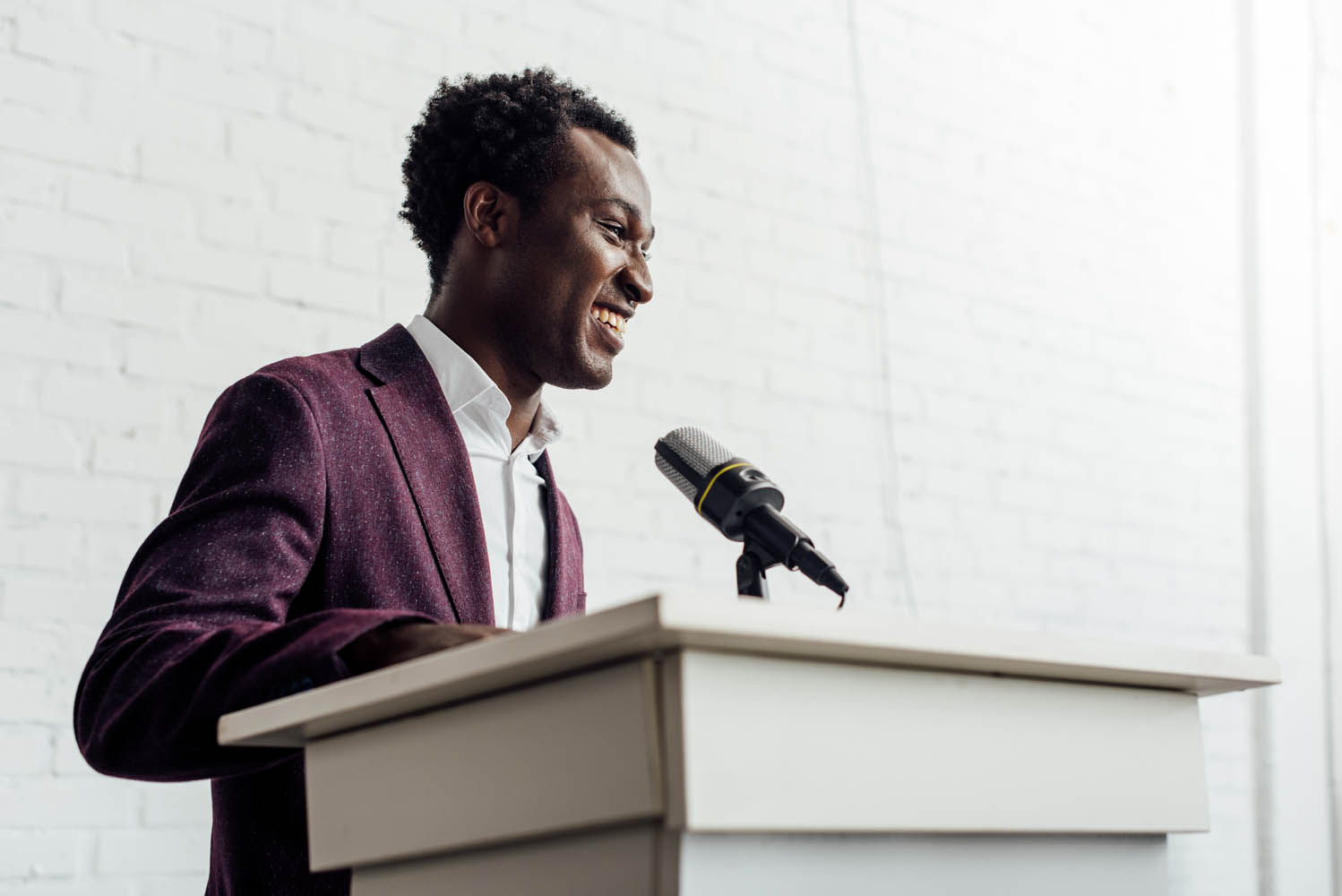 african american businessman in formal wear smiling during conference